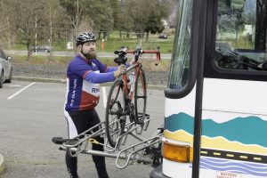 Veteran loading a bike on a bus bike rack.